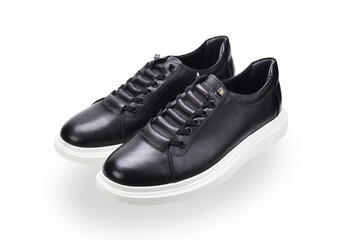 A pair of black sneakers with white soles isolated on a white background. 