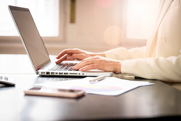 Close-up shot of inancial accountant businesswoman's hand while typing on laptop