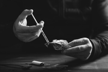 Drug addict man or drug dealer prepares heroin.