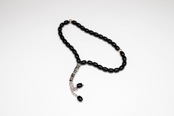 Black Muslim rosary beads on white background