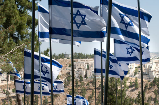 Multiple, large, blue and white flags of the State of Israel rippling in the wind during the observance of Independence and Memorial day holidays at the Har Herzl military cemetery in Jerusalem.