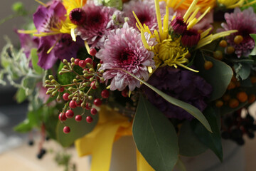 Obraz na płótnie Canvas Beautiful bouquet of autumn flowers with yellow ribbon