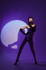 Fototapeta na wymiar Beautiful fashionable girl posing on stage spotlight silhouette disco color background unaltered