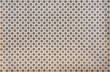 Floral pattern on vintage endpaper, repeating small black ornaments on beige background
