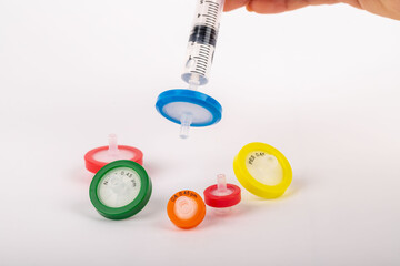 Scientist demonstrating the use of needle tip filters in a laboratory setting.