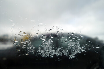 View from car window with rain drops and snow.