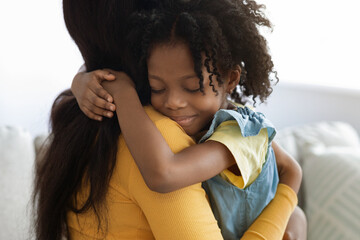 Obraz premium Cute Litttle African American Girl Embracing Her Mommy At Home