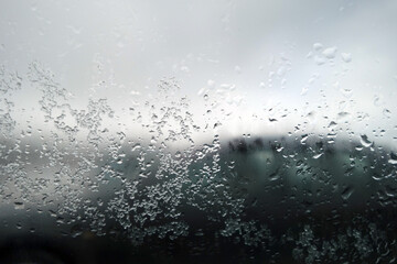 Snow and rain drops on car window. Blur defocused abstract