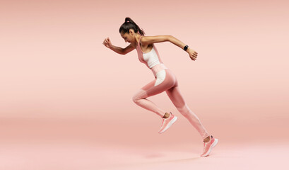 Fototapeta na wymiar Full length photo of lady jump high up training marathon finish line wear sports suit isolated pink color background
