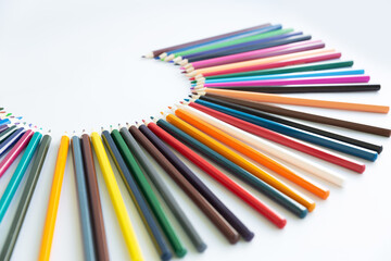Set of colored watercolor pencils arranged in a semicircle isolated on a white background