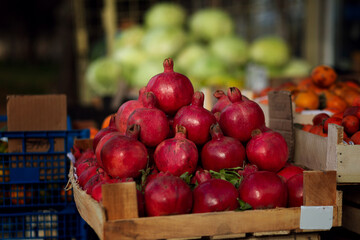 A red ripe pomegranate on the counter of a street vegetable store