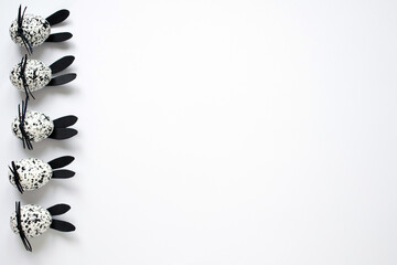 Easter eggs decorated as spotted black and white bunnies on the white background, copy space.