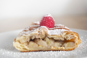 Apple quiche with powdered sugar and garnished with raspberries