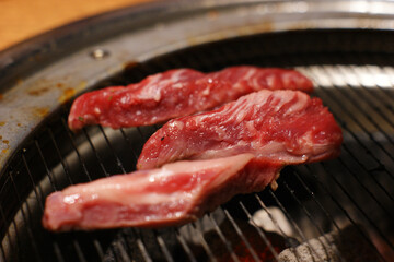 Put red raw meat on the grill and grill it.