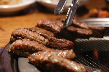 Grilled beef is neatly placed on the grill.