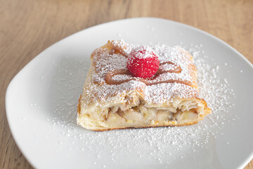 Apple quiche with powdered sugar and garnished with raspberries