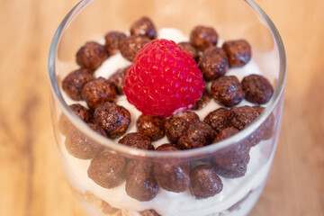 weet dessert with raspberries, mascarpone cream and cream, sprinkled with chocolate chip cookies