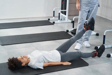 Fototapeta premium Woman doing leg exercise in the gym