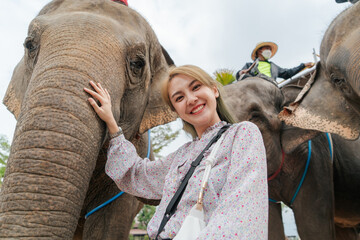 Happiness smile traveler Asian woman taking a photo with elephant tourist after recovered from pandemic coronavirus. Travel trip new normal concept after pandemic COVID-19