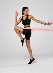 Sportswoman exercising with resistance band. Female with working out with elastic band on white background