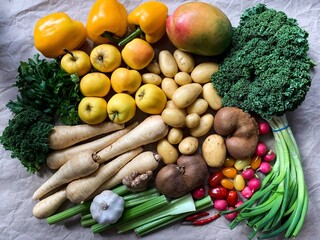 Healthy eating: grocery shopping or delivery of fresh fruits and vegetables. Rich vitamin vegetables. Variety of fruits and vegetables on craft paper. Fresh potatoes parsnips carrots apples kiwi peppe
