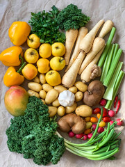 Healthy eating: grocery shopping or delivery of fresh fruits and vegetables. Rich vitamin vegetables. Variety of fruits and vegetables on craft paper. Fresh potatoes parsnips carrots apples kiwi peppe