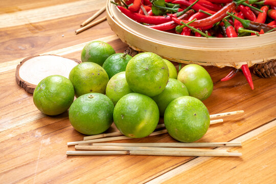 Red hot chili peppers and lime on bamboo basket, Fresh red chili and lime, sour and spicy seasoning for Thai hot and spicy dishes.