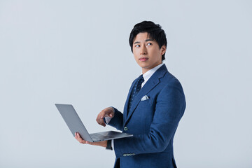 ノートパソコンを操作する20代ビジネスマン