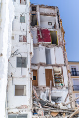 building in ruin with a collapsed wall and visible damaged apartments