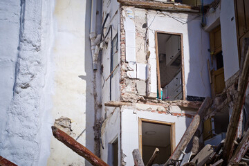 building in ruin with a collapsed wall and visible damaged apartments