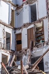 building in ruin with a collapsed wall and visible damaged apartments