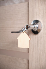 Key with keychain in form house in door lock.