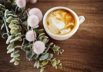 Schilderijen op glas Cup of coffee with flowers. Morning coffee concept © konradbak