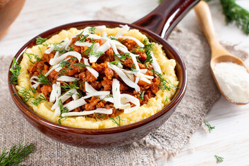Italian polenta with ragu' bolognese on a wooden table