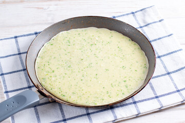 Delicious thin pancake with herbs in frying pan