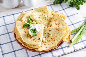 Thin pancakes with herbs. Salty Pancakes with green onions. Delicious food for a bite to eat. Traditional Russian pancakes for Maslenitsa.