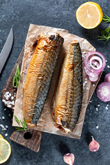 Smoked mackerel on a cutting board on a stone background. Mediterranean food, herring fish, top view