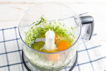 The process of making dough for thin pancakes with onions in the blender bowl on a table. Recipe step by step. Food for Maslenitsa