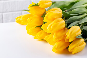 A bouquet of yellow tulips. A greeting card. Delicate flowers. Copy space