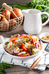 Salad with chicken liver and vegetables in a plate on the table