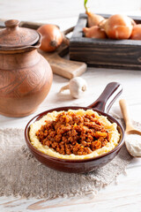 Polenta with fresh bolognese sauce on a plate on a wooden table