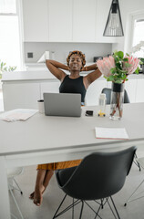 Black African businesswoman relaxing, stretching, working from home