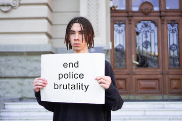 A male student is protesting against police brutality in front of courthouse.