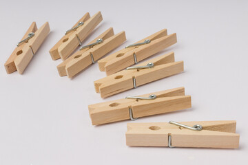 wooden clothespins lie in a corner on a white background with copy space