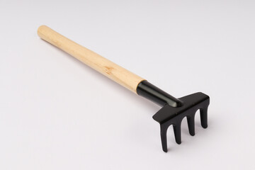 rake with wooden handle for indoor plants on a white background