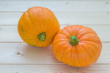 two ripe pumpkins on a wooden table