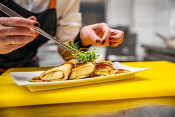 chef cooking food. Chef's hands cooking pancakes crepe rolls with ground meat on kitchen