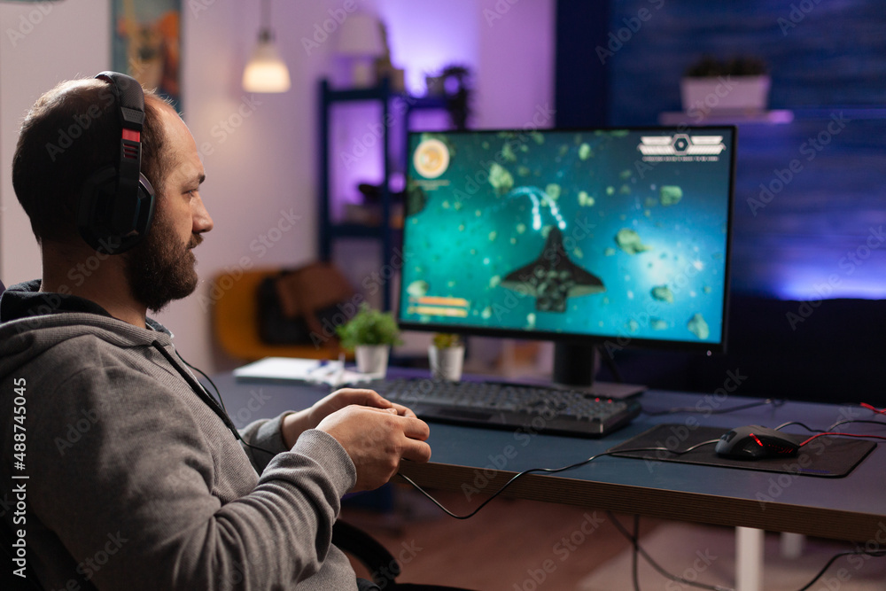 Poster person playing video games with joystick and headset on computer. player using controller and audio 