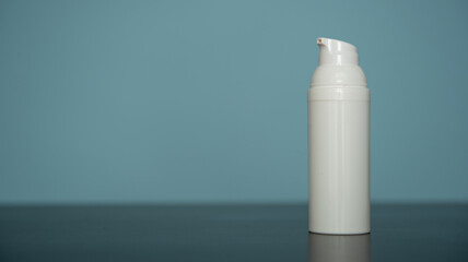 Flacon de crème pour visage en plastique blanc sur fond bleu - mockup pour produit cosmétique