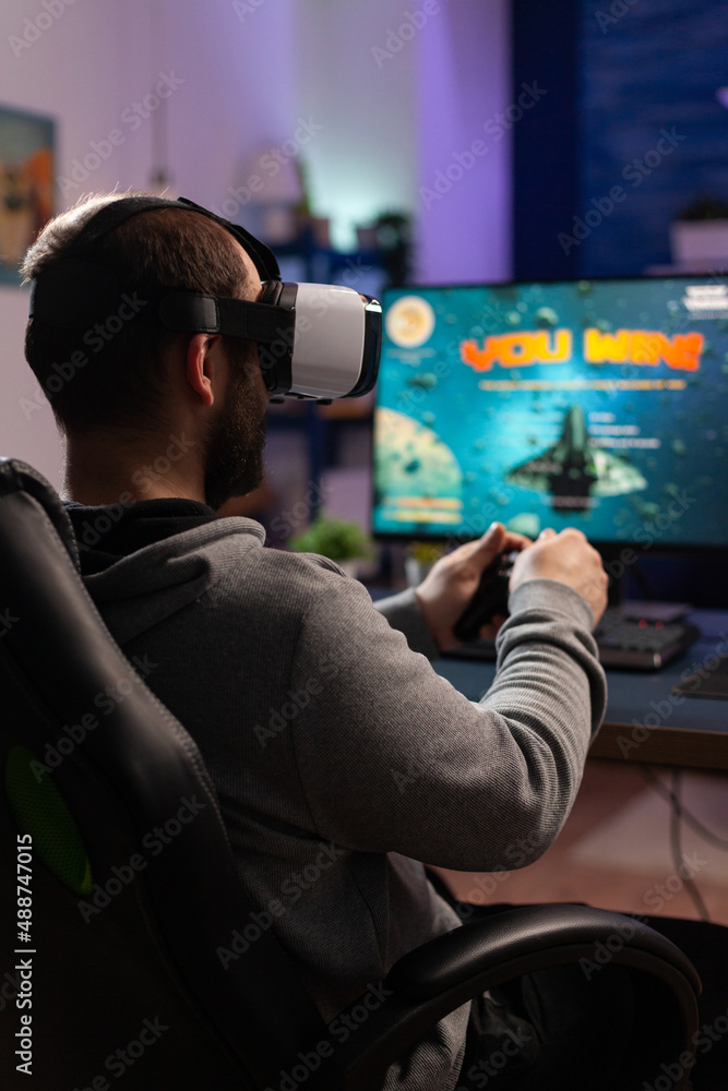 Poster man playing video games with joystick and vr glasses. player winning game while he uses controller a